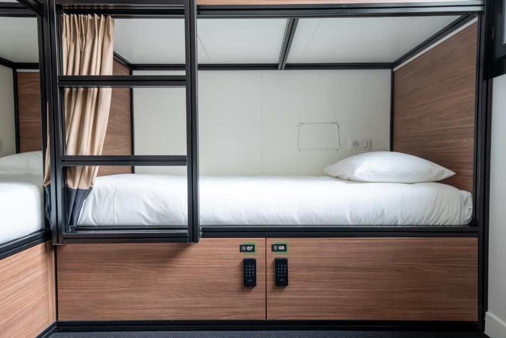1 dormitorio con 2 literas y armarios de madera en Beau M Paris, en París