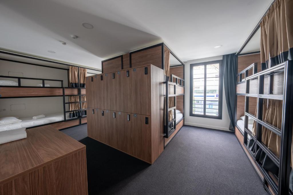 a room with lots of wooden shelves and a large window at Beau M Paris in Paris