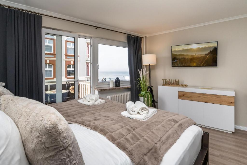 a bedroom with a bed and a large window at Meerliebe in Westerland (Sylt)