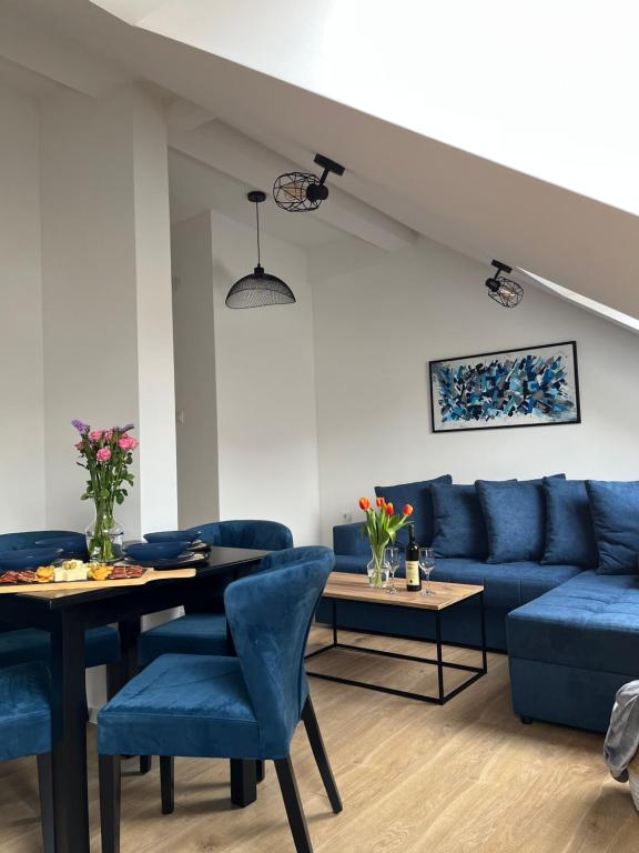 uma sala de estar com sofás azuis e uma mesa em Loft apart Pluzine em Pluzine