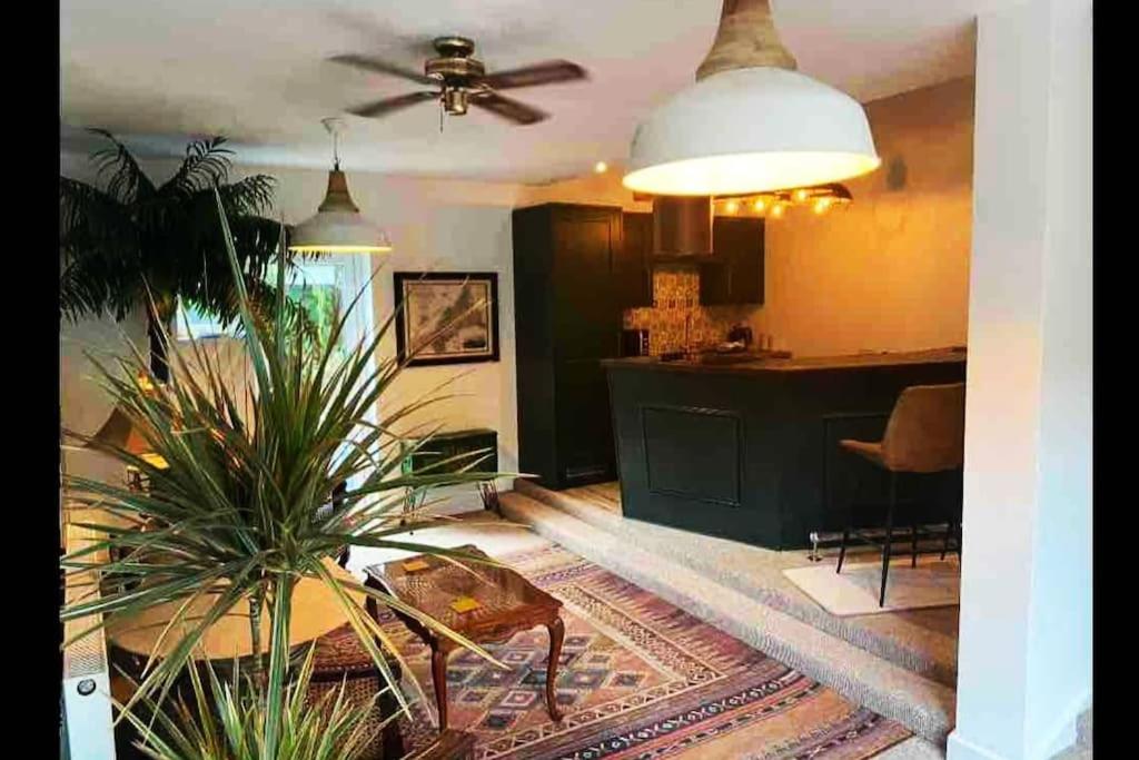 a living room with a ceiling fan and a table at Palm View Luxury Botanical Themed apartment with sauna in St Austell