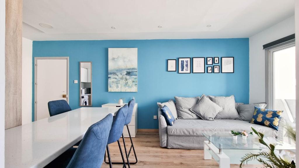 een blauwe woonkamer met een tafel en een bank bij Modern Retreat: 2br Stylish Apt with Comfy Rooms! Smart TV with 200MBPS Internet in Larnaka