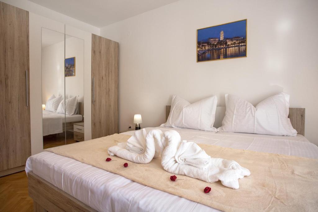 uma cama branca com uma pilha de toalhas em Apartment Radman em Split