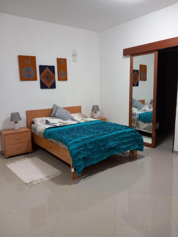 a bedroom with a bed and a mirror in it at Casa Kyara T0 in Praia
