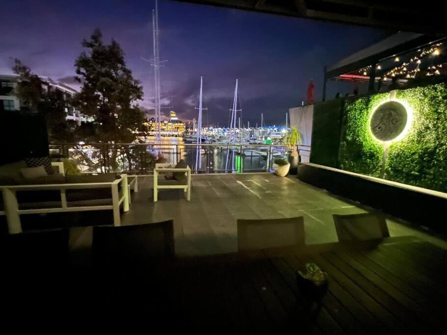 einen Balkon mit Blick auf den Yachthafen in der Nacht in der Unterkunft THE VIADUCT WATERFRONT LUXURY - Views & Location! in Auckland