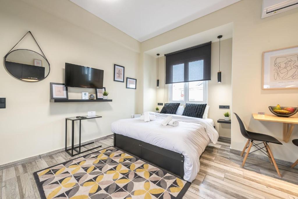 1 dormitorio con cama, mesa y escritorio en Petralona Stylish Penthouse, en Atenas