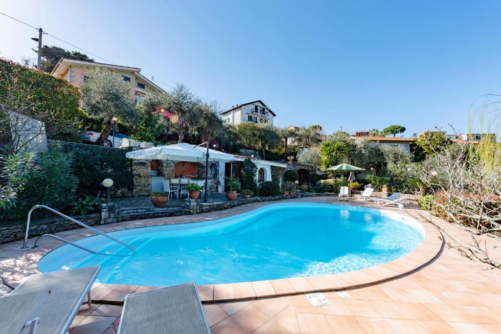 a large blue swimming pool in a yard at Villa Renetta with Swimming pool and Jacuzzi and parking in Rapallo