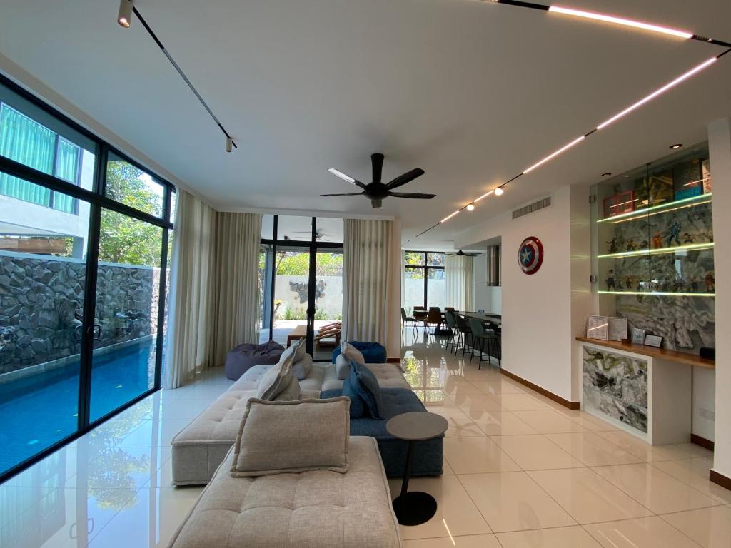 a living room with a couch and a ceiling fan at Ikiru 18 Private Saltwater Pool Villa, 3 Ensuite BR, Outdoor BBQ, 5 mins to Beach in Pantai Cenang