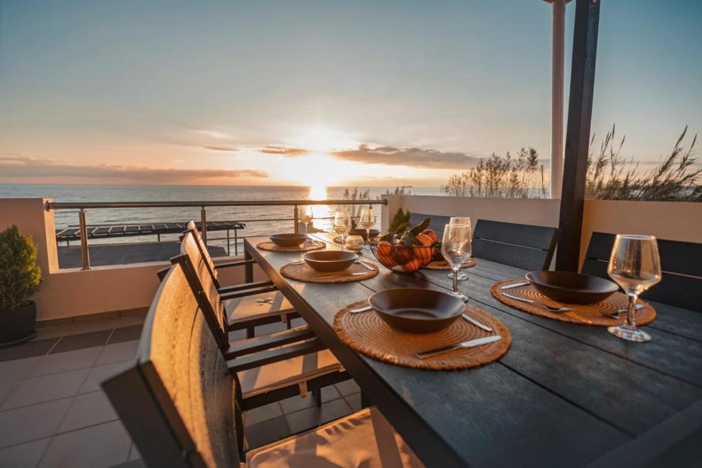 a table on a balcony with a view of the ocean at Sunset Beach House in Agios Georgios