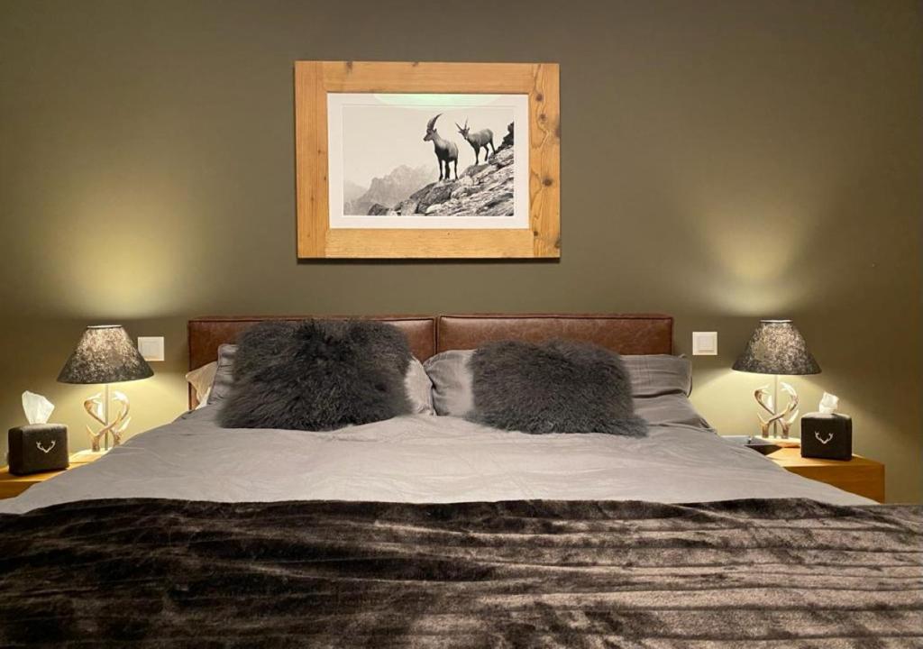 1 cama con 2 almohadas y una foto de ciervo en Alpenstil, 4 Pax, zentral, 1 Parkplatz - RE31, en St. Moritz