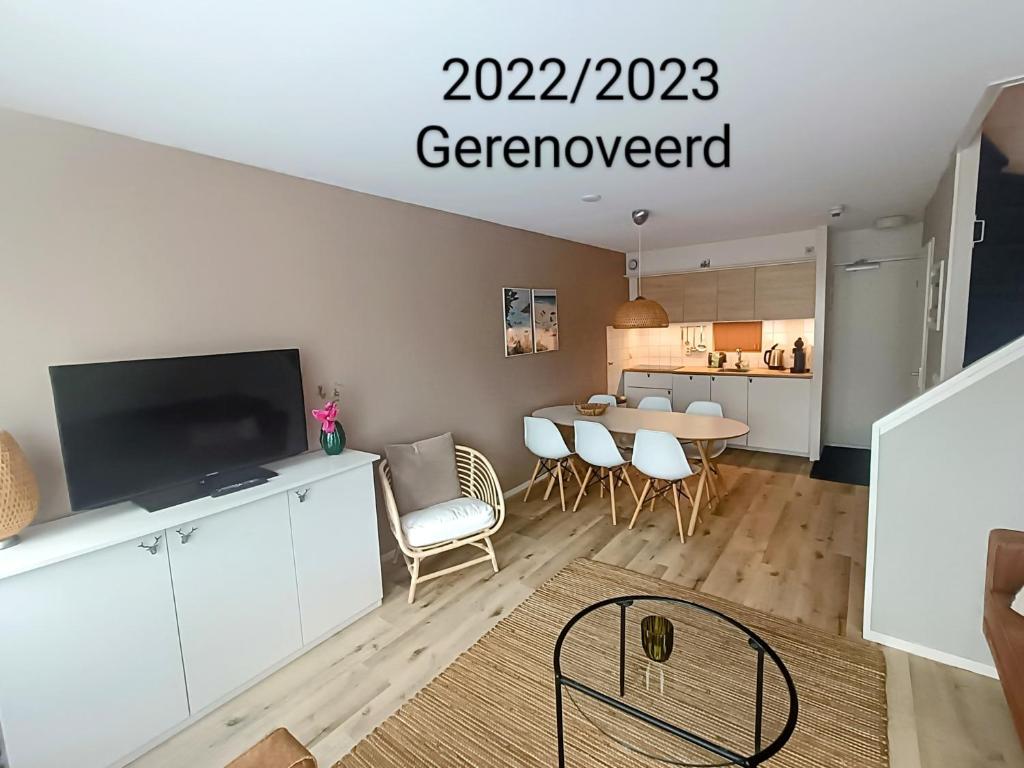 een woonkamer met een tafel en een televisie bij Amelander Kaap 39 in Hollum