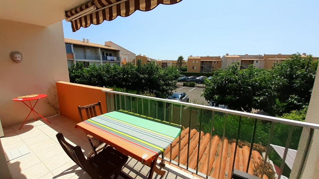 un balcon avec une table et des chaises sur un balcon dans l'établissement MALDIVES Joli T2 cabine proche plage Richelieu Cap d'Agde, au Cap d'Agde