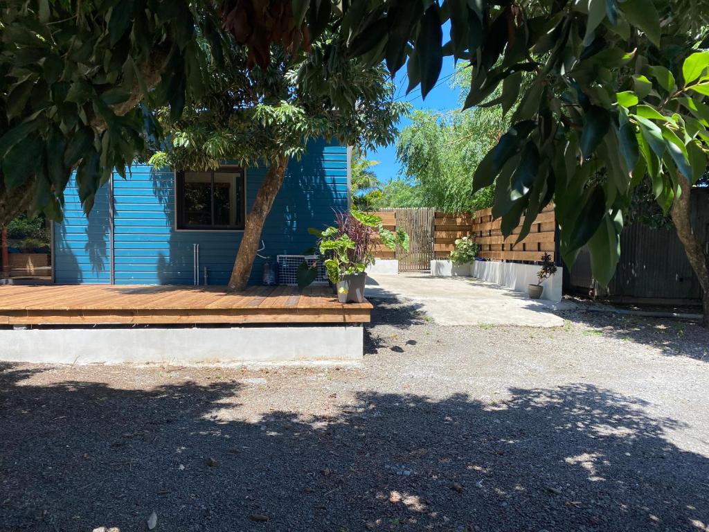 a blue house with a wooden bench in a yard at Le Palan in Saint-Pierre