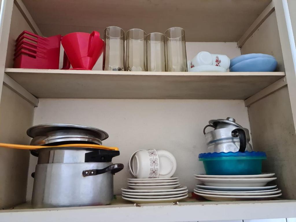 a shelf with plates and cups and utensils at Departamento Playa Bristol Casino in Mar del Plata