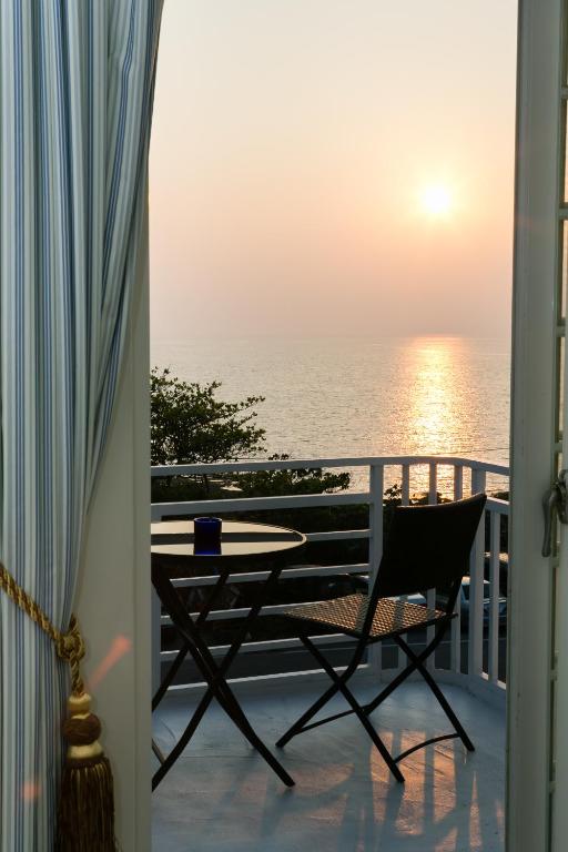 a balcony with a table and a view of the ocean at 岸戀民宿 墾丁船帆石 in Eluan