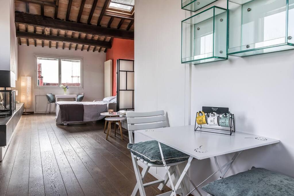een keuken en een woonkamer met een tafel en stoelen bij enJoy Home - Mansarda nel cuore di Padova in Padua