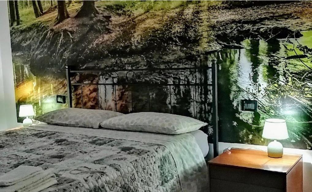 una camera con un letto e una parete con un dipinto di Come a casa tua a Falconara Marittima