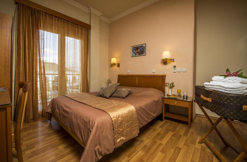 a bedroom with a bed and a large window at Lakonia Hotel in Sparta