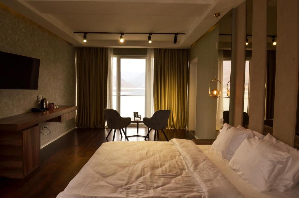 Hotel Cami في ديبار: غرفة نوم بسرير كبير وطاولة مع كراسي