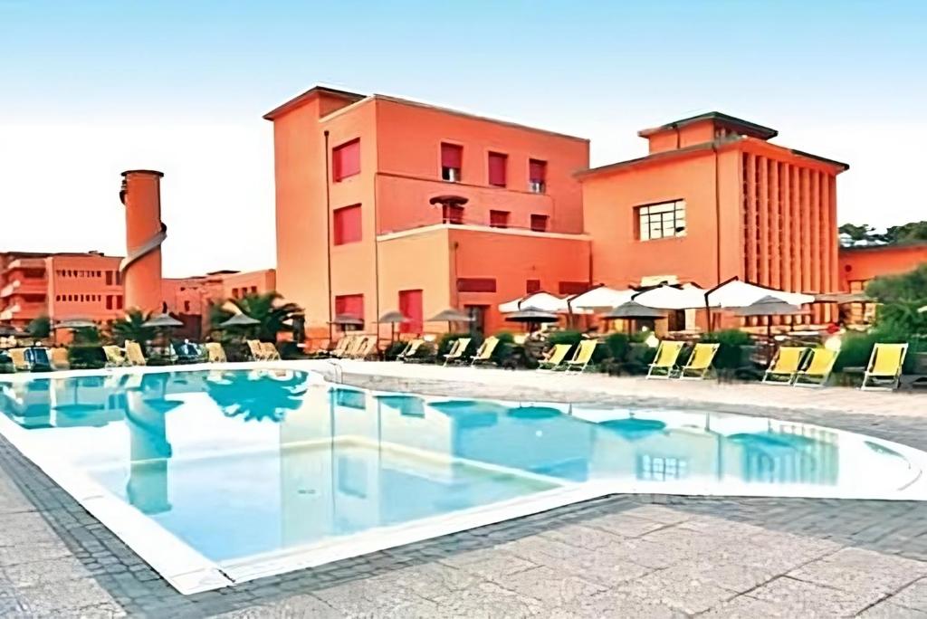 a swimming pool in front of a building at Regina Beach Holiday Apartments in Tirrenia