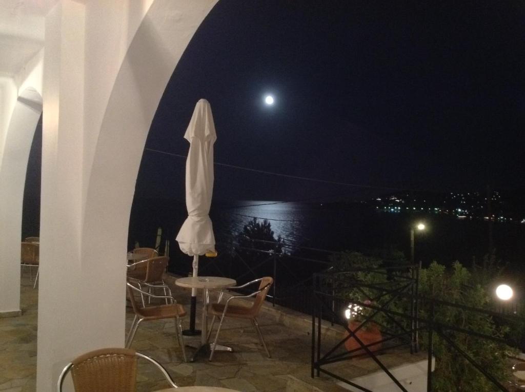 einen Blick auf den Mond von einer Terrasse in der Nacht in der Unterkunft Travlos Studios in Póros