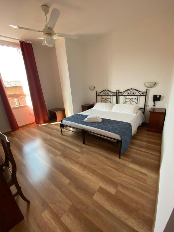 una camera con letto e pavimento in legno di Hotel San Giorgio a Bologna