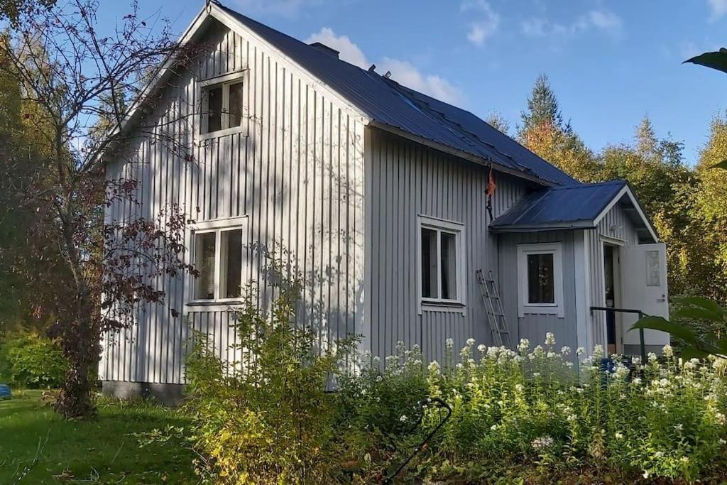 ein graues Haus mit Solardach in der Unterkunft Villa Mäntysaari luonnonrauhaa kaupungin lähellä. in Kontiolahti