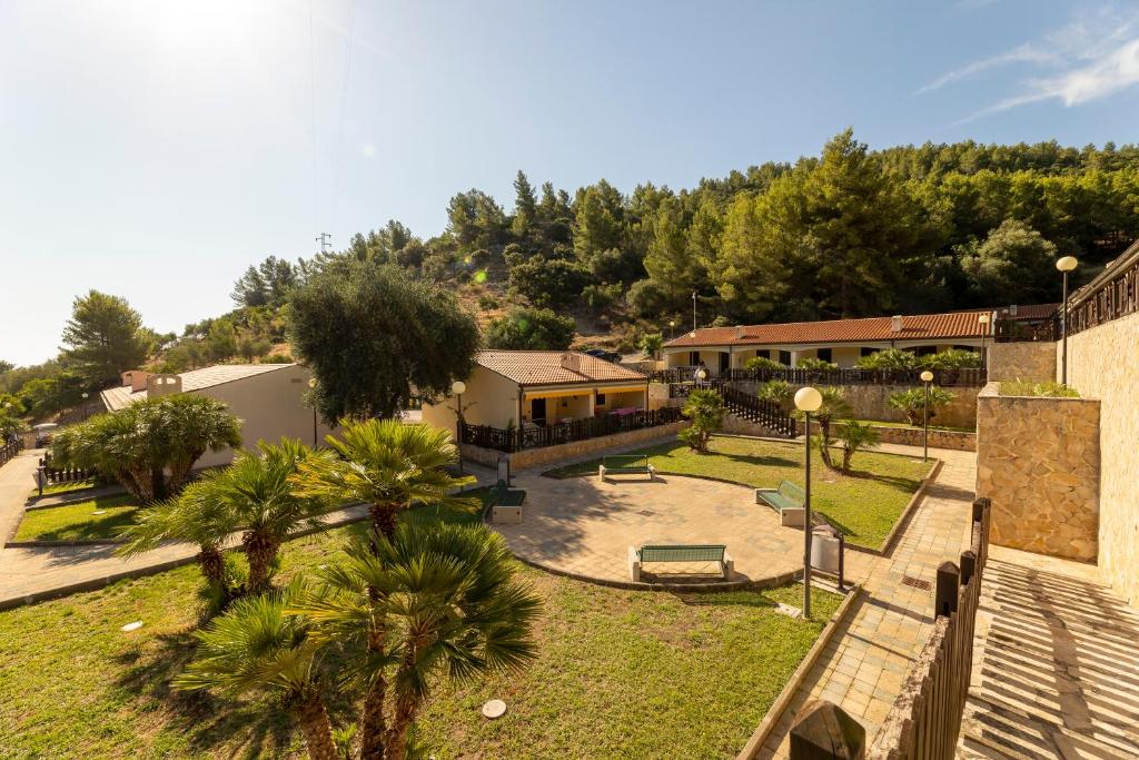 a park with palm trees and a building at Pugnochiuso Resort Villette Belvedere in Pugnochiuso