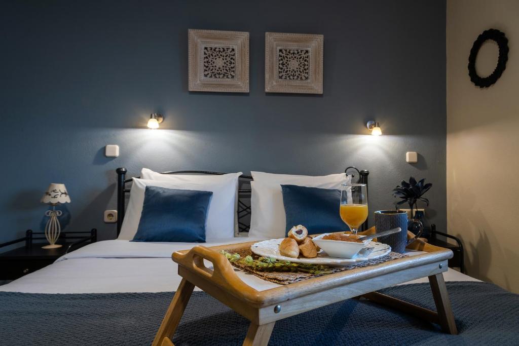 a bedroom with a bed with a tray of food on a table at Jo Marinis Rooms in Korinthos