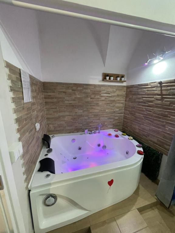 a bath tub with a purple floor in a room at I Gradini dell Eden in Naples