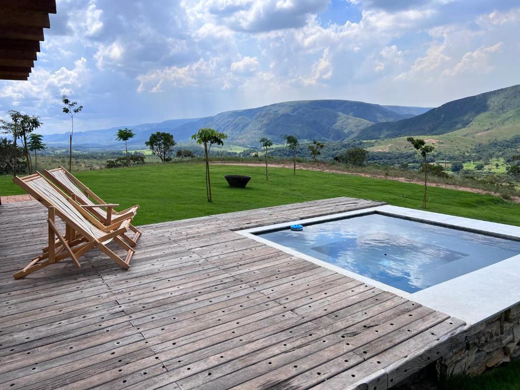 una terraza de madera con una silla y una piscina en Refúgio Morro Alto, en Delfinópolis
