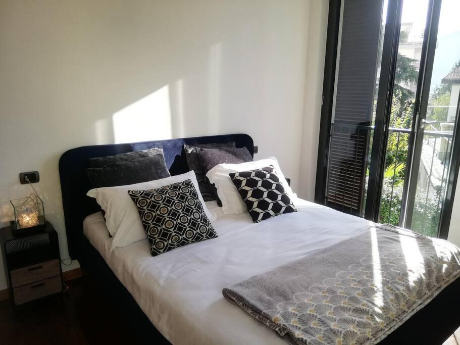 un letto con cuscini sopra in una camera da letto di La Casa di David a Como