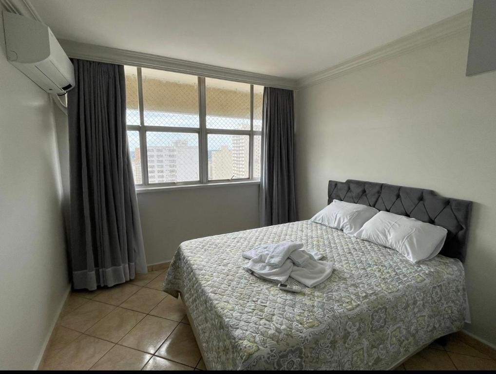 a bedroom with a bed with a hat on it at Apartamento aconchegante 1911 in Goiânia