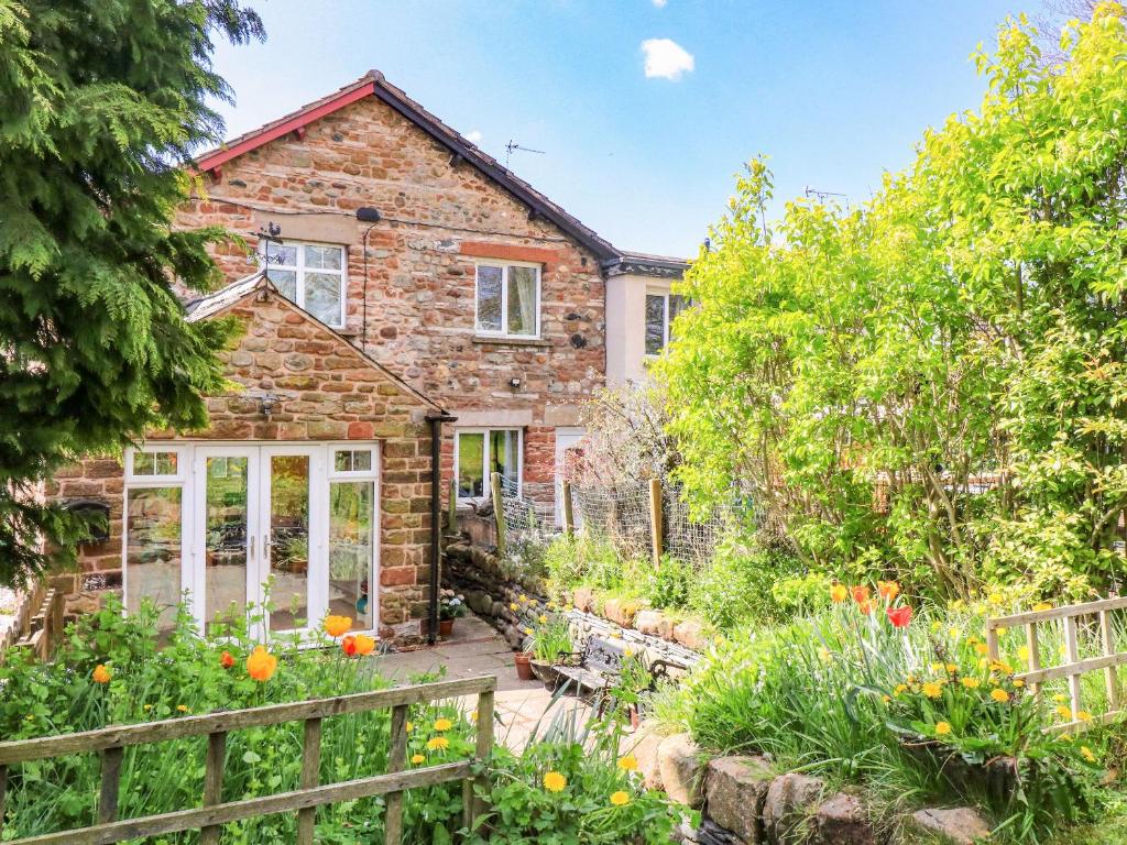 an old brick house with a garden in front of it at Mirfield in Newbiggin