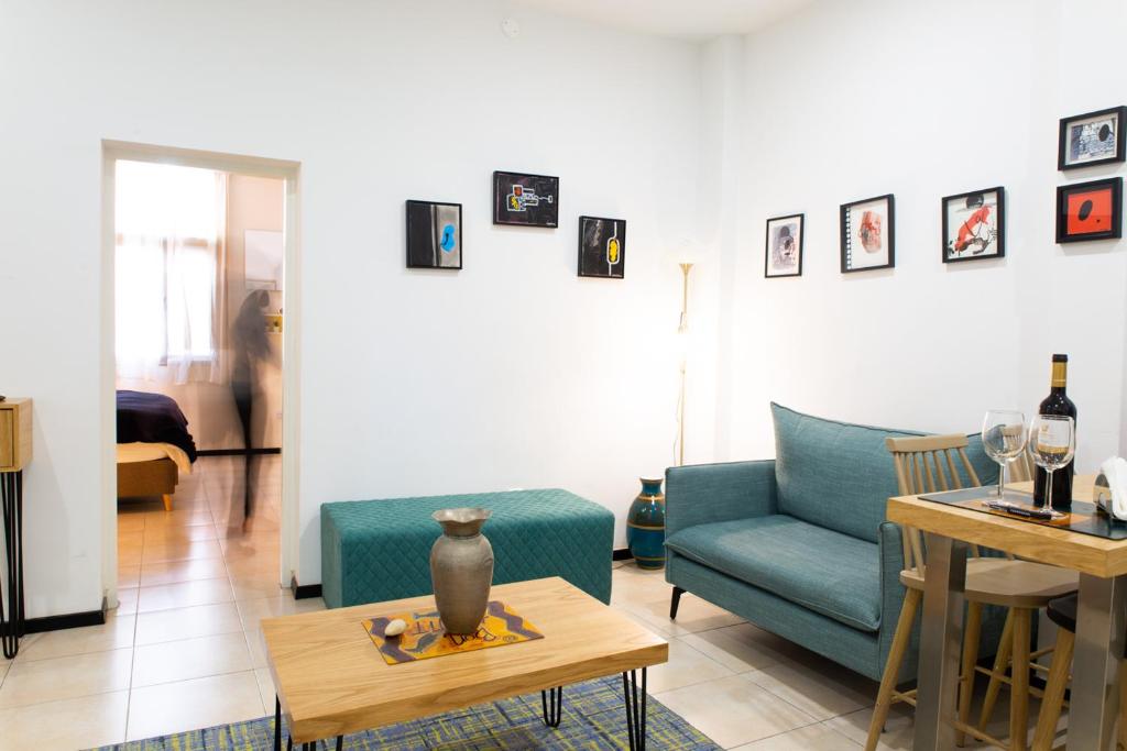 een woonkamer met een blauwe bank en een tafel bij House in Shalma in Tel Aviv
