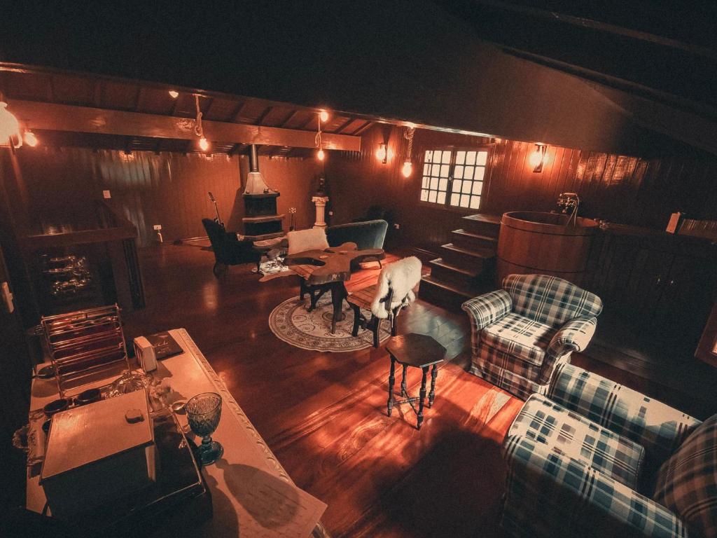a living room with a couch and chairs and a table at Cabana Retrô com lareira e Ofurô em Monte Verde in Monte Verde