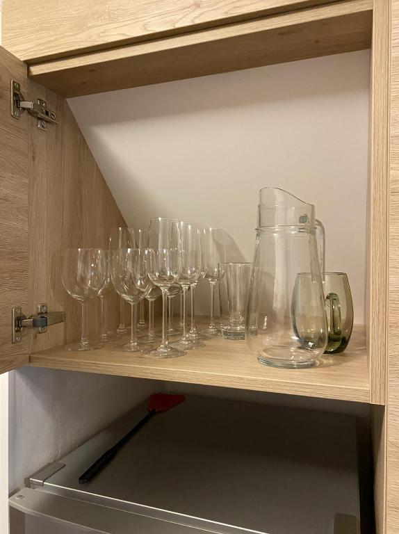 rząd kieliszków do wina na półce w obiekcie Apartmán 430 w mieście Deštné v Orlických horách