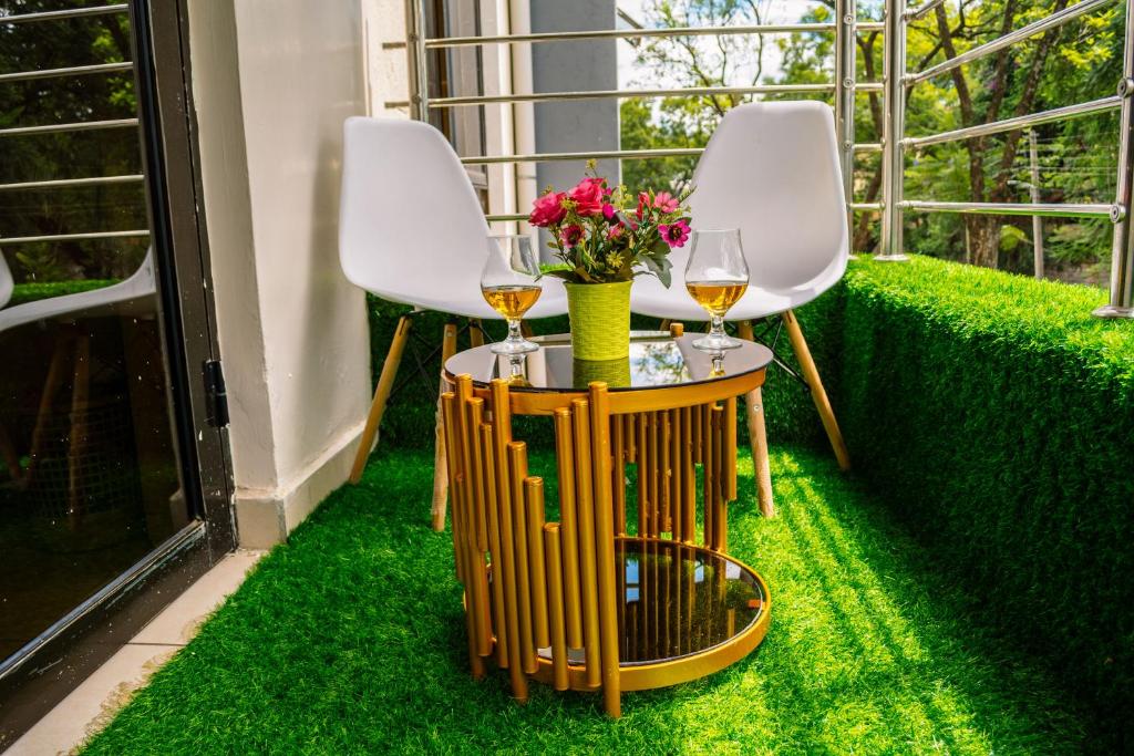 dos sillas y una mesa con dos copas de vino en The Fancy Luxurious 3 bedroom apartment, en Nakuru