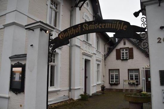 a sign in front of a white building at Kaisermühle Hotel & Gasthof in Viersen