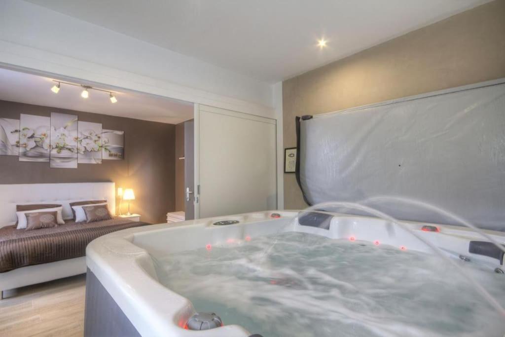 uma grande banheira num quarto com uma cama em Gîte Darcey la Jolie 6/8 pers. em Darcey