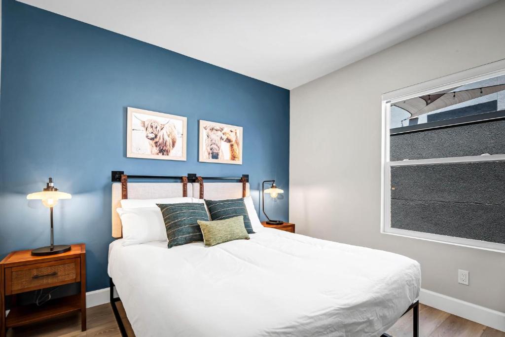 ein Schlafzimmer mit einer Wand mit blauen Akzenten und einem Bett in der Unterkunft Single Bedroom - Queen Size. Heart of Downtown Vista in Vista
