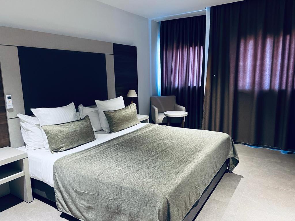 ein Schlafzimmer mit einem großen Bett in einem Zimmer in der Unterkunft Grand Hotel Central Conakry in Conakry