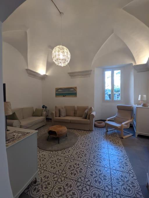 ein großes Wohnzimmer mit Sofas und einem Kronleuchter in der Unterkunft Casa di Nico in Finale Ligure