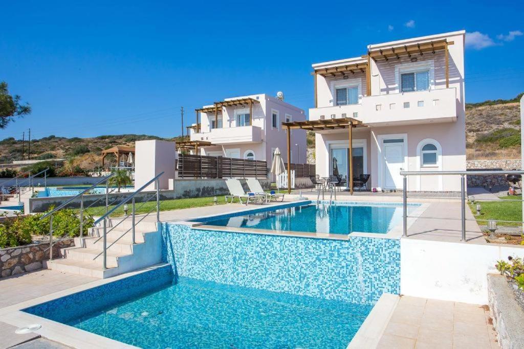 a villa with a swimming pool in front of a house at Villa Regina - Double Pool Paradise in Lachania