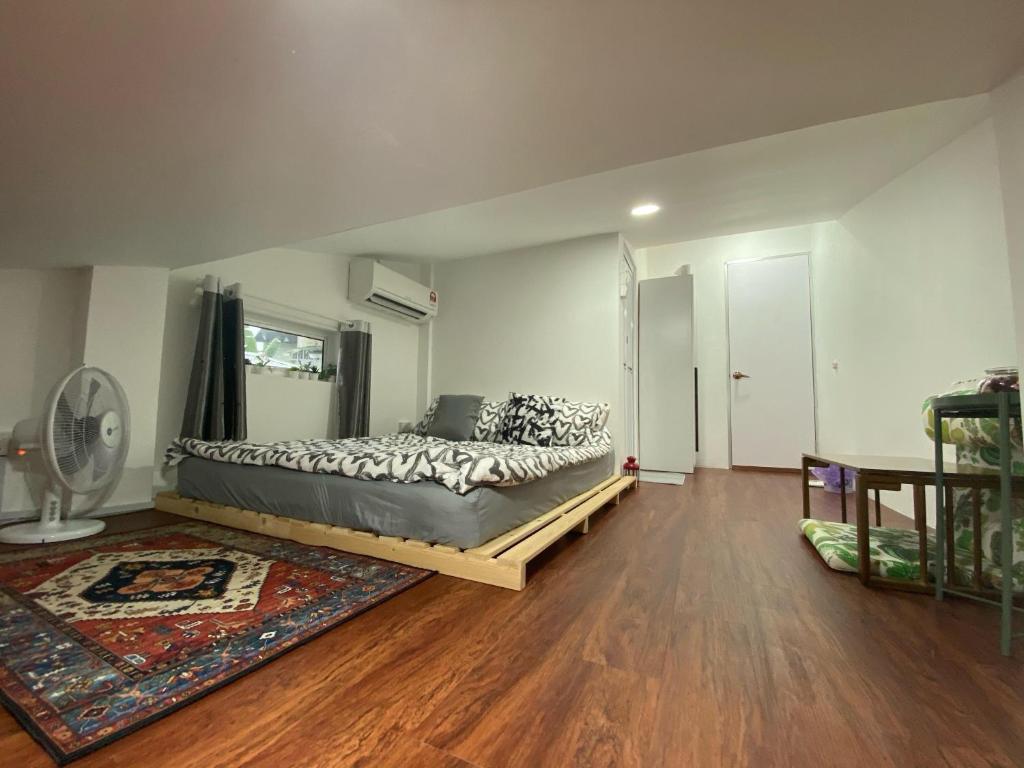 1 dormitorio con 1 cama grande en el suelo de madera en Sweet Loft Homestay en Johor Bahru