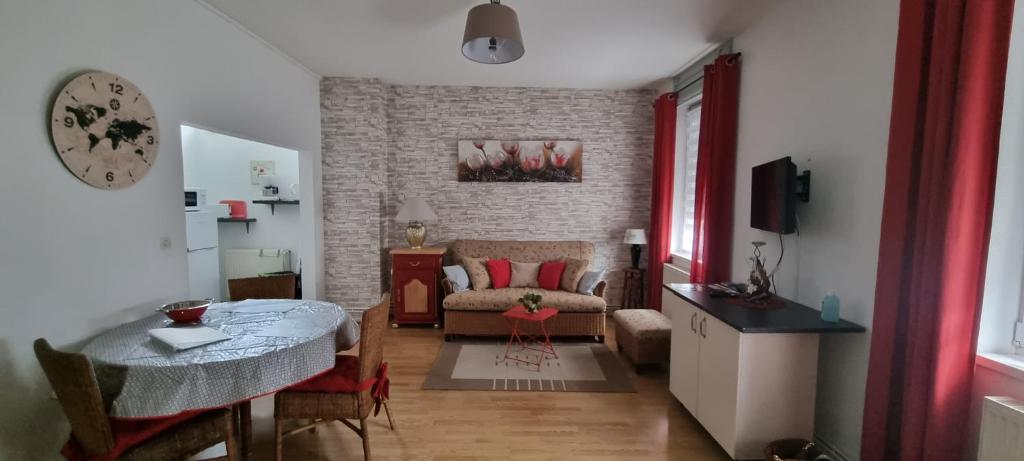 a living room with a table and a couch at appartement meublé romain in Niederbronn-les-Bains