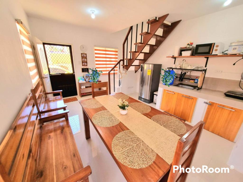 a dining room with a table and a kitchen at Palawan two bedroom home in puerto princesa city in Puerto Princesa City