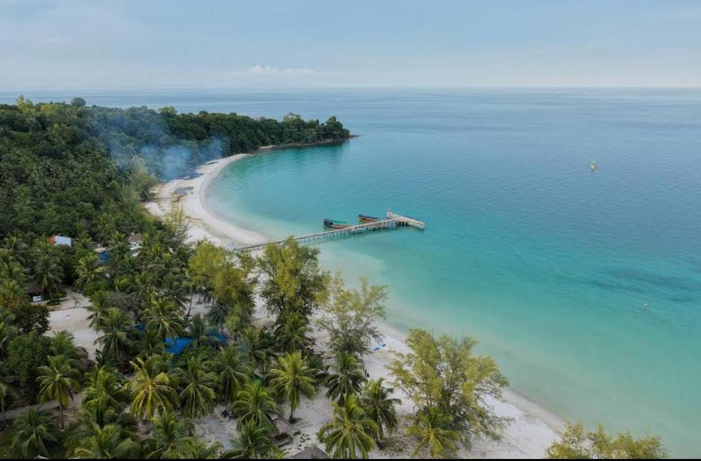 an aerial view of a beach with a dock in the water at Bunnan Bungalows and Restaurant in Koh Rong Island