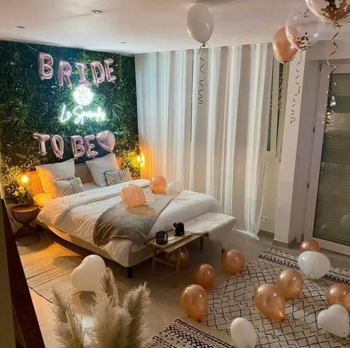 een slaapkamer met een bed met ballonnen en een bord bij Un écrin de zénitude by Lesparadis in Metz