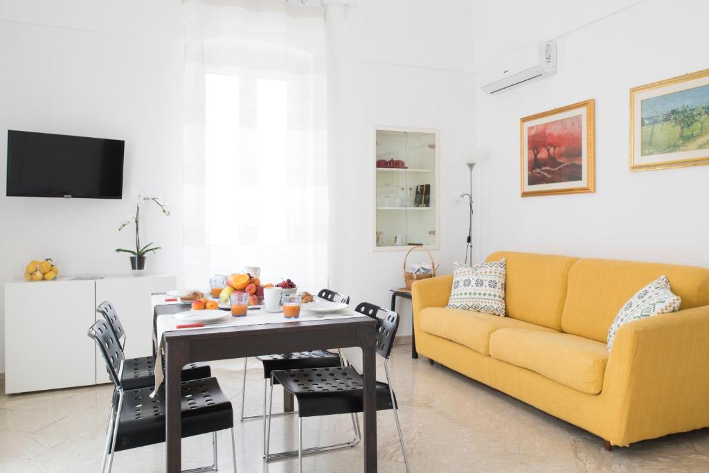 a living room with a yellow couch and a table at Casa Fernanda in Monopoli